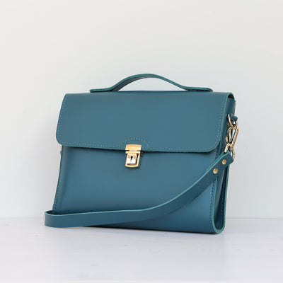 Picture of women's stylish bike bag in the style of a teal leather satchel bike bag
